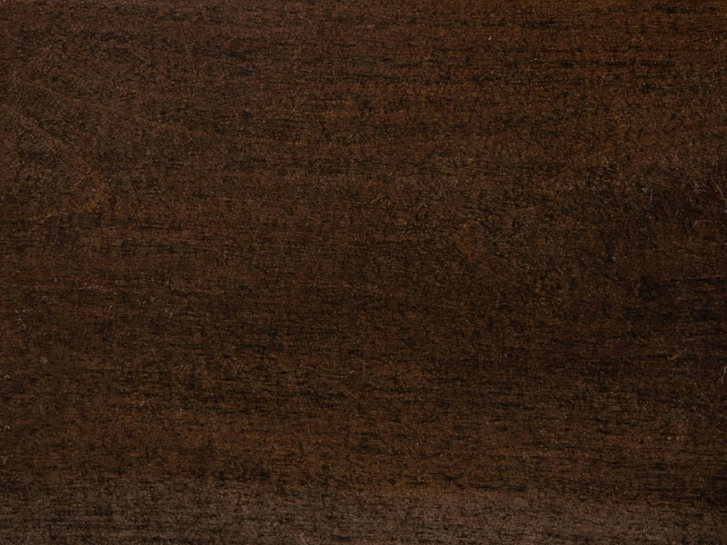 A close-up view of the Charred Ember on Maple Sample from James+James showcases a dark brown textured wooden surface. The wood grain is visible, giving the surface a natural, rustic appearance. The color varies slightly, with some areas appearing slightly darker or lighter.