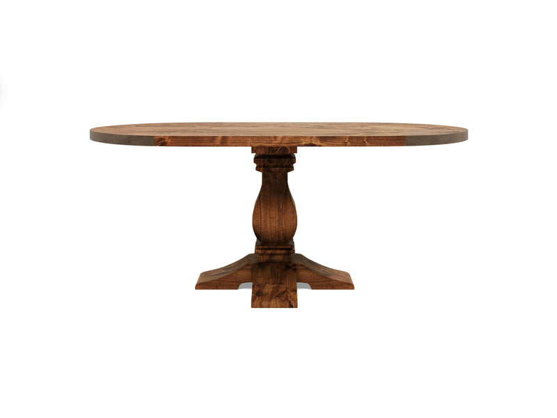 The James+James Heirloom Oval Dining Table - Tuscany features a rustic, natural finish and a sturdy pedestal base adorned with ornate carvings. It stands on four curved legs and boasts a simple yet elegant design, making it suitable for any dining area or kitchen.