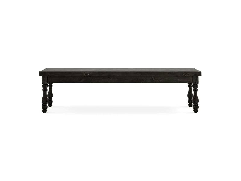 The Annli Bench - Charred Ember by James+James features a long, rectangular surface made of dark wood with thick, ornamental legs. It is centered against a white background.